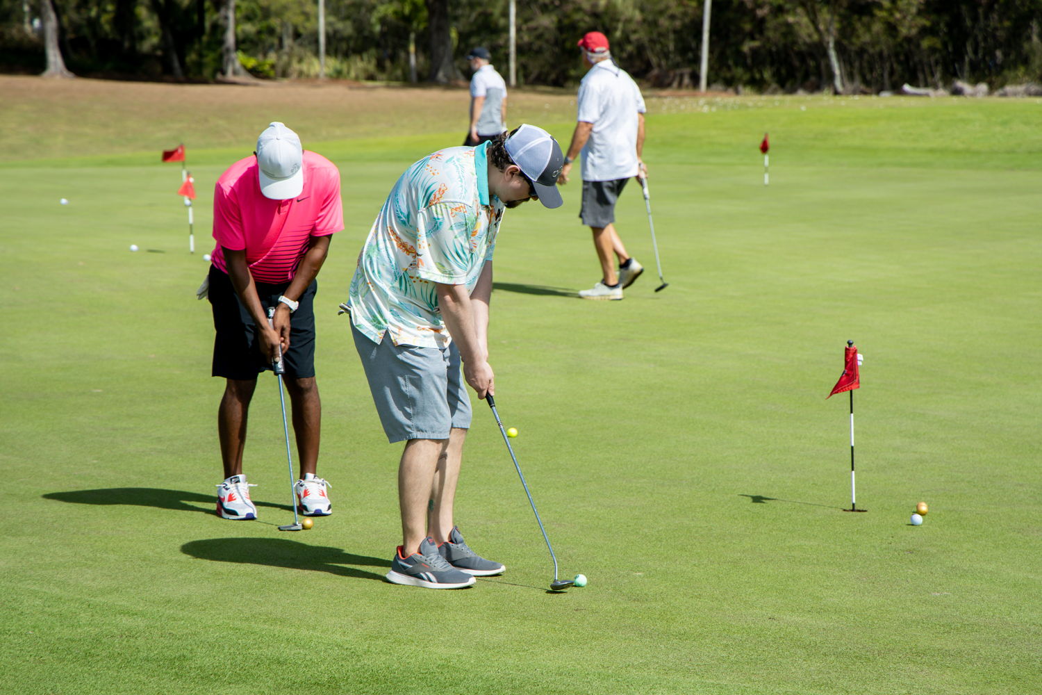 Golfers warm up on the putting green.