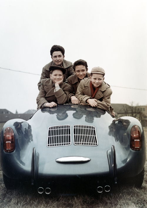 Wolfgang Porsche (1953, derecha) junto a sus hermanos Hans-Peter (izq.) y Ferdinand Alexander y su hermana Gerhard. Sobre un Porsche 550 Spyder