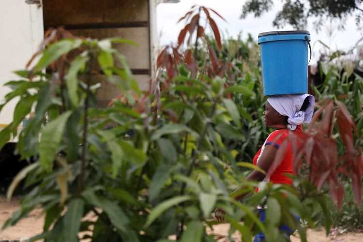 Precious Kapeka collects water from a well in Stoneridge. The community has benefitted from MSF installing boreholes and wastewater management system in Stoneridge to prevent bacterial contamination which used to occur as a result of underground septic tanks. Photographer: Dorothy Meck