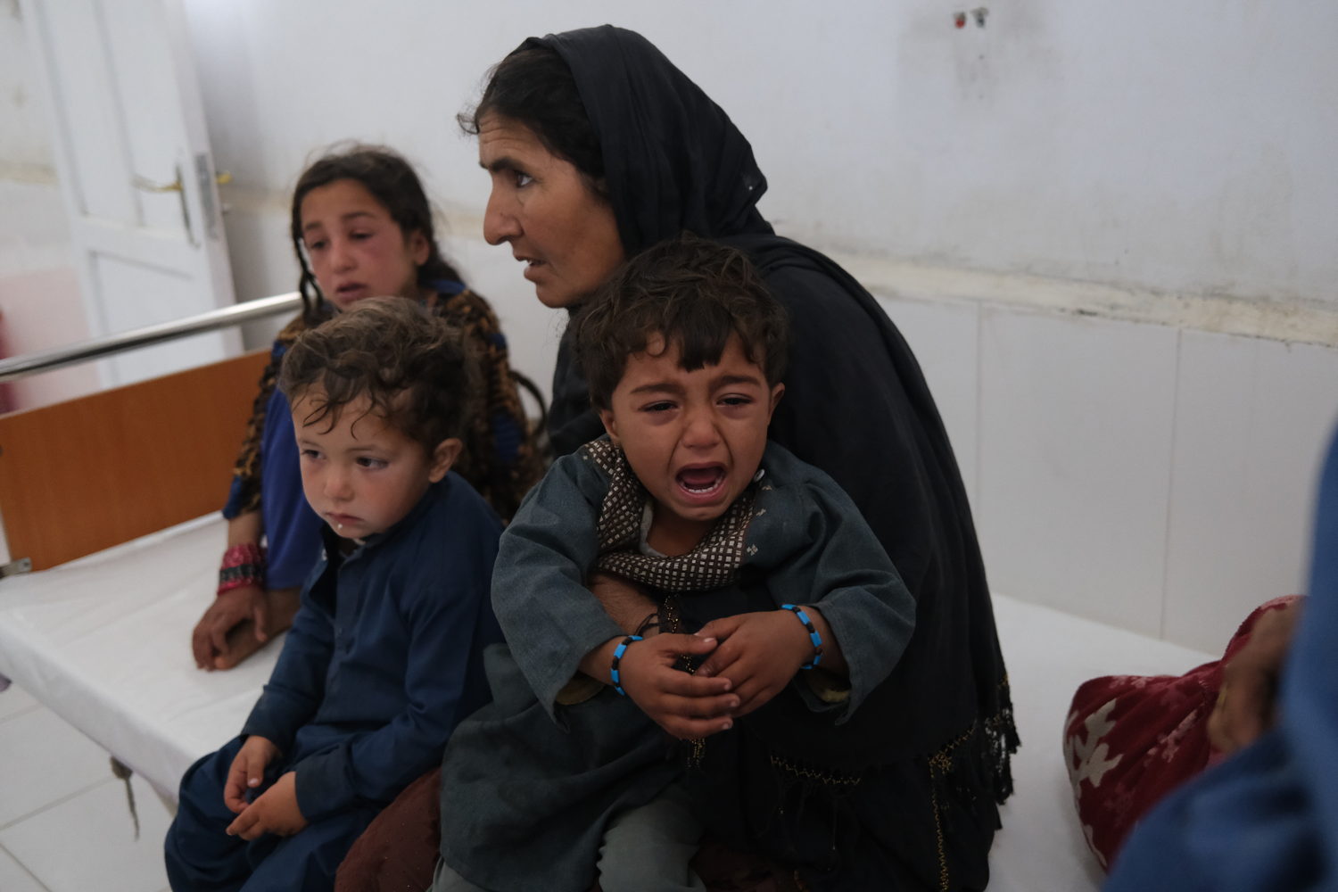 Han Bibi with her grandchildren in the measles screening unit at Boost hospital. She lives with her 12 grandchildren, all of whom caught measles. 