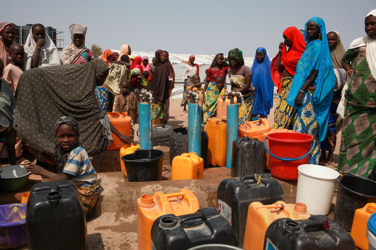 There is a tense atmosphere at one of the boreholes in Pulka, as women try to get enough water for their families. Photographer: Scott Hamilton