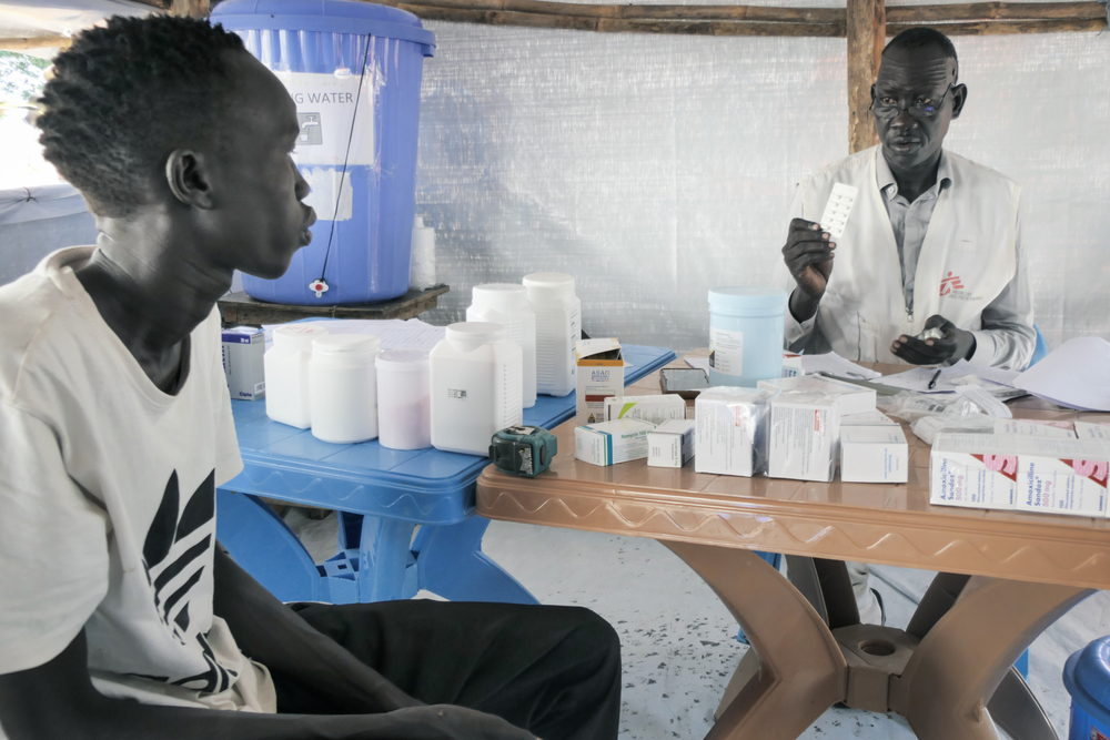 MSF Clinical Officer Chuol Hoth examines a child at the MSF Mobile Clinic in Bulukat transit centre, Upper Nile State South Sudan. The Bulukat transit centre hosts thousands of returnees living under temporary shelters. Their living conditions are deplorable as the now muddy terrain heightens their life with onset of diseases. Photographer: Gale Julius Dada | Location: South Sudan | Date: 16/08/2023