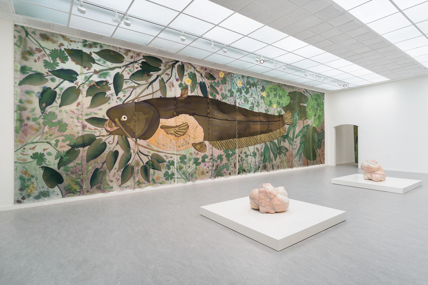 Daniel Dewar & Grégory Gicquel, Installation view The Wet Wing at Z33, Hasselt. Foreground: Marble sculpture with snails and body fragments, 2025. Background: Silk painting with catfish, common water-crowfoot, pondweed, duck potato and water lilies, 2025. Commissioned by Z33. Courtesy the artists. Photo: Lola Pertsowsky