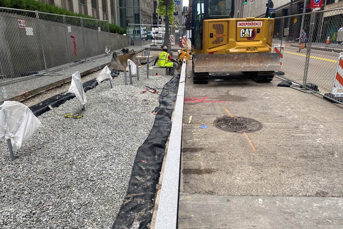 Granite curb being placed at Fifth Avenue and William Penn Place