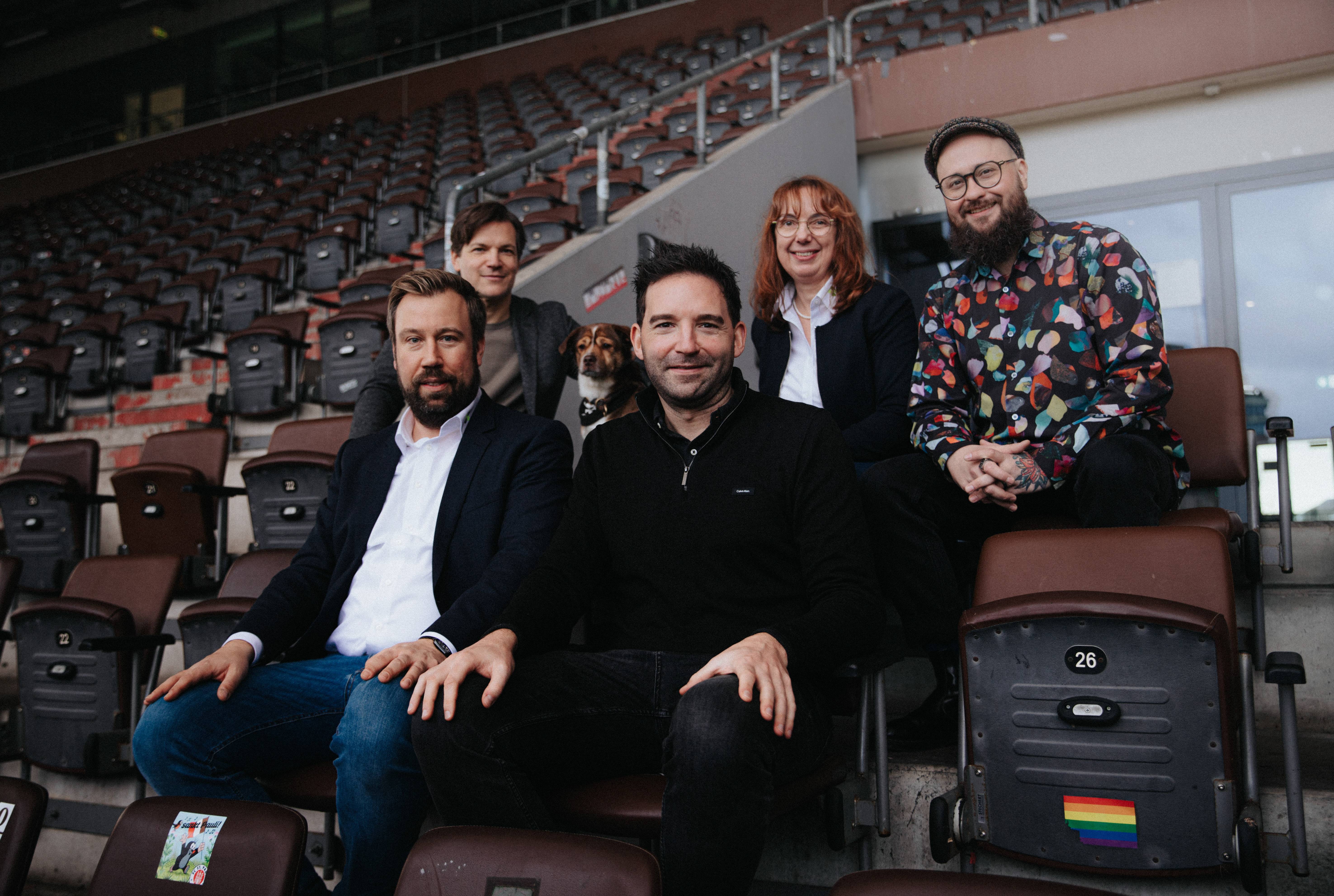 Auf eine starke Partnerschaft: Wilken Engelbracht (Kaufmännischer Geschäftsleiter beim FC St. Pauli), Hund Frippe, Imke Brammer-Rahlfs (Vorstandsvorsitzende der Uelzener), Mikko Pihavaara (Head of Sales Partnerships & Hospitality beim FC St. Pauli) in der hinteren Reihe (v.l.n.r.), Dr. Sebastian Tiedemann (Bereichsleiter Markt & Kunde bei der Uelzener) und Florian Dederichs (Bereichsleiter Vermarktung beim FC St. Pauli) in der vorderen Reihe (v.l.n.r.) freuen sich auf die Zusammenarbeit. ​ Bildquelle: FC St. Pauli