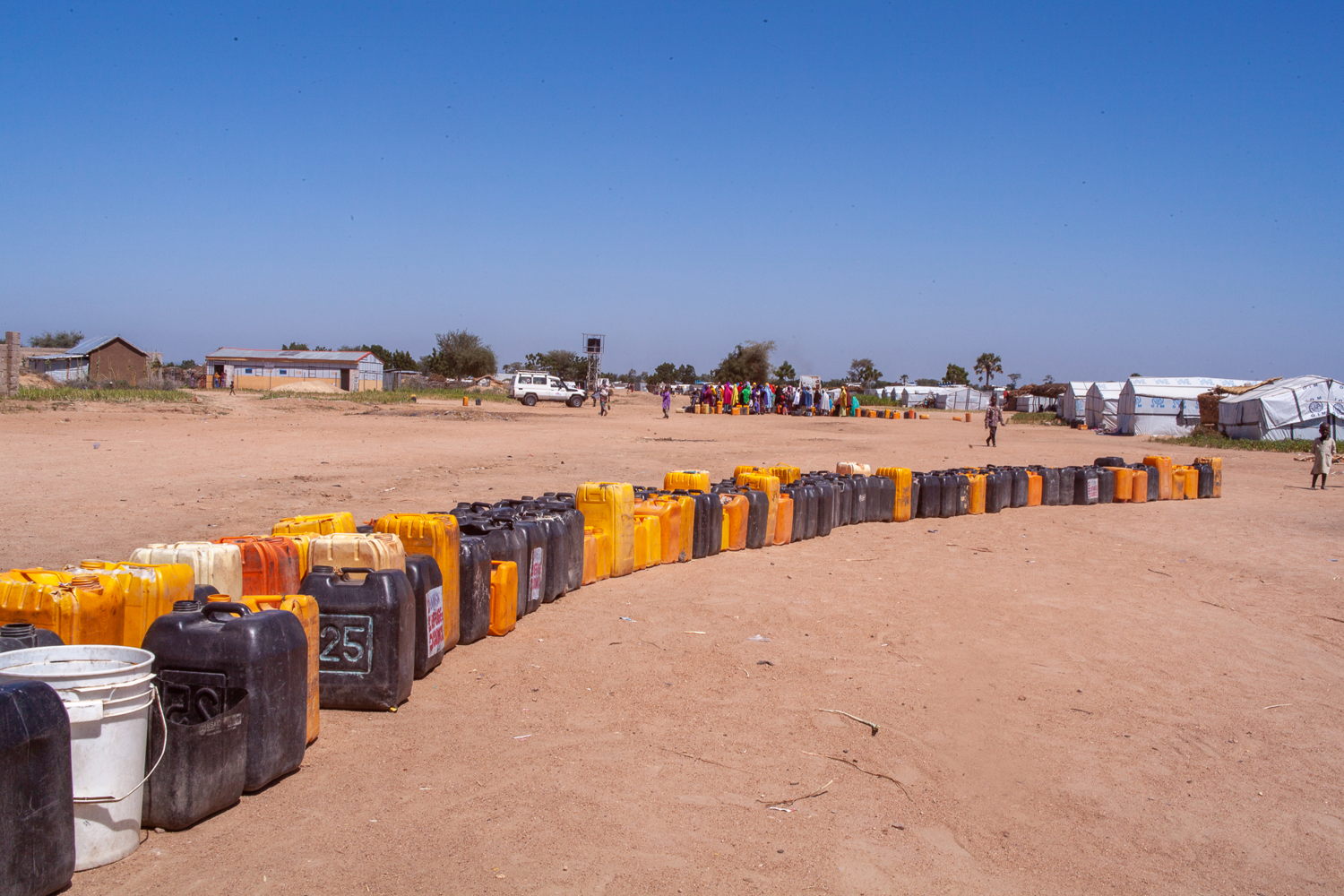 A line of jerry cans in front of a borehole in Gwoza ready to be filled. Photographer: Scott Hamilton