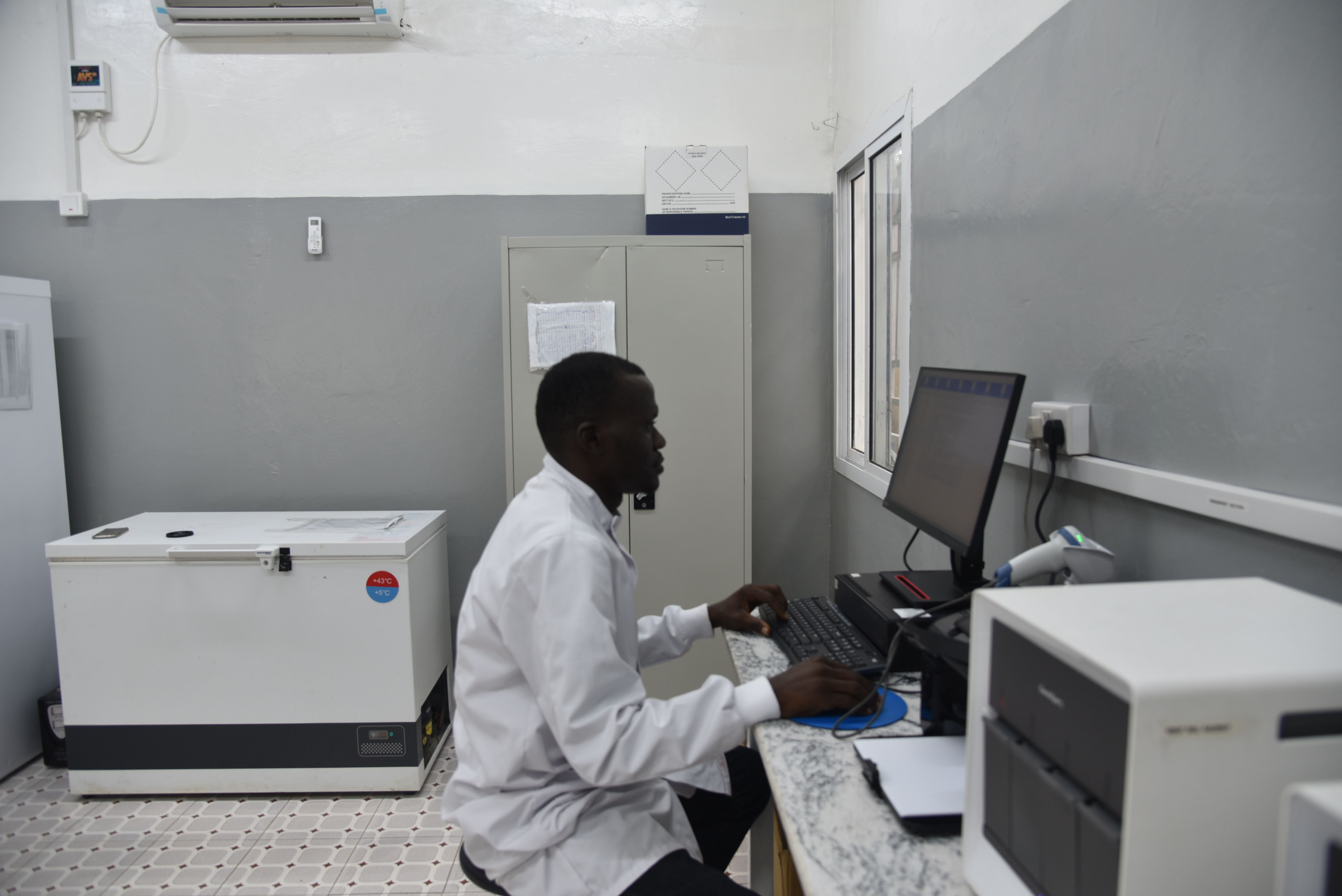 MSF Laboratory supervisor Ibrahim Massaquoi inside the Makeni Regional hospital tuberculosis laboratory, Bombali district, Sierra Leone, recording results of TB tests.Test samples in the form of sputum and stool are transported from the 12 Direct Observation Therapy (DOT) sites that MSF supports across the Bombali district. The samples are sent to the Makeni Regional hospital for TB testing using GeneXpert machines for quality molecular diagnosis, as per WHO guidelines. Test results are shared with patients, through the staff working at the DOT sites, within 48 hours.The laboratory also supports the monitoring of the health status of patients treated for Drug Resistant Tuberculosis (DR-TB). Routine laboratory tests are performed to measure progress of their treatment and potential need for treatment of other comorbidities (HIV, Hepatitis B, anemia, etc.). Patients affected with DR-TB come to the Makeni DR-TB ward on a monthly basis for medical check-up, drug prescription refill and an opportunity to discuss with MSF psychosocial support team and receive a food package to support them for the duration of their treatments. | Date taken: 08/12/2023 | Photographer: Ammar Obeidat