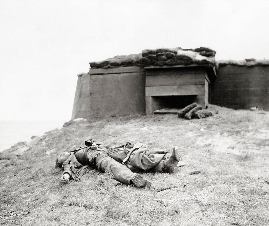 The body of a German soldier is lying in front of a bunker overlooking the coast. June 1944. Utah beach was defended by the 709th Static Infantry Division which actually contained a large number of Ostlegionen troops, recruited from occupied Eastern European countries. Utah Beach, Normandy, France. AKG2492692 © akg-images