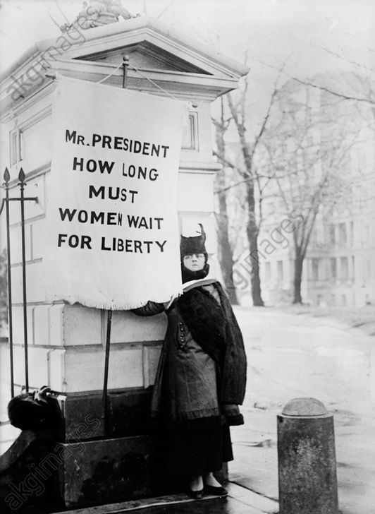 Suffragette with banner: "Mr. President How Long Must Women Wait for Liberty?", Washington DC, 1917. AKG4507922