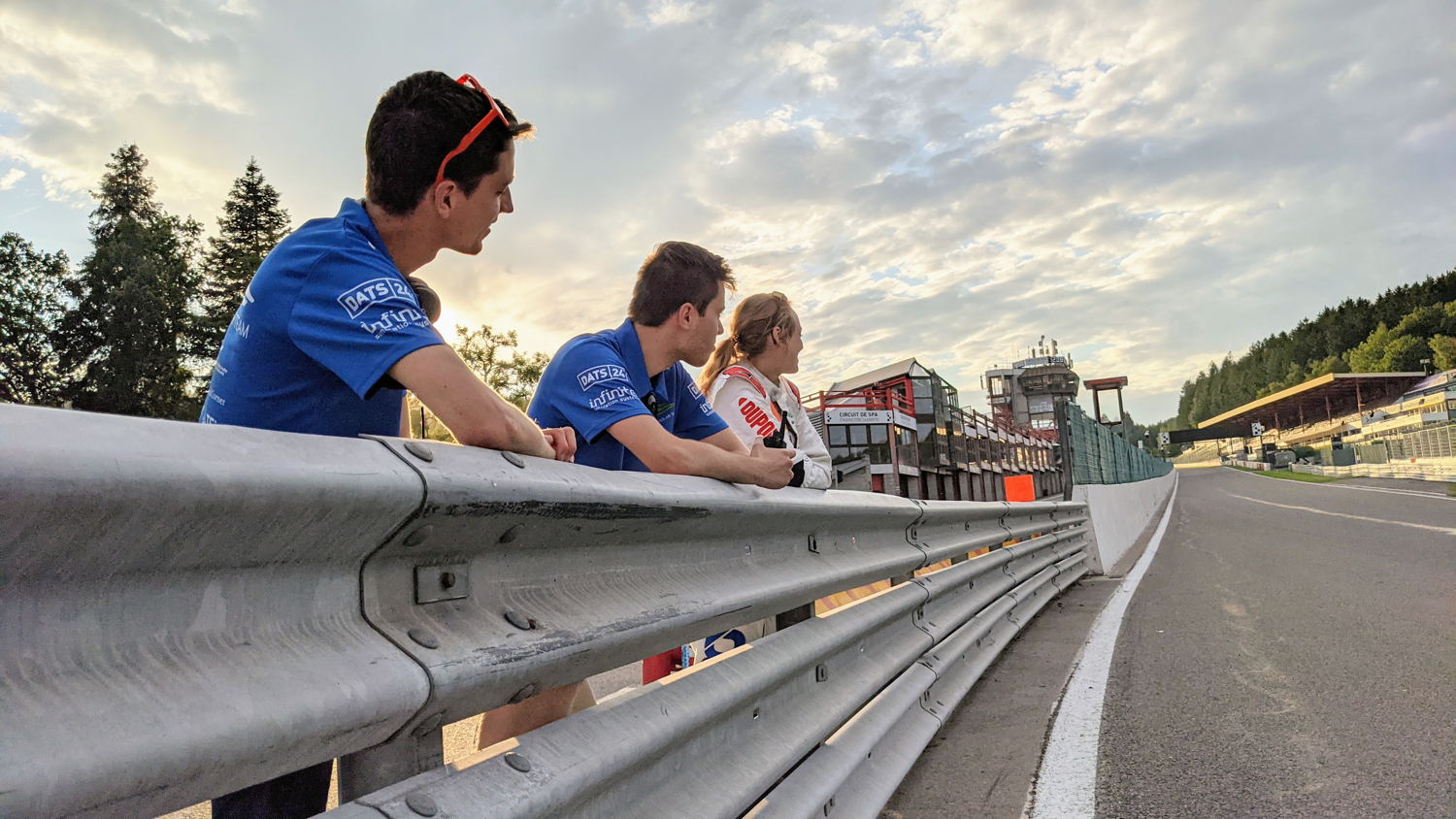 Teamleden wachtend op de zonnewagen aan de zijkant van het circuit.
