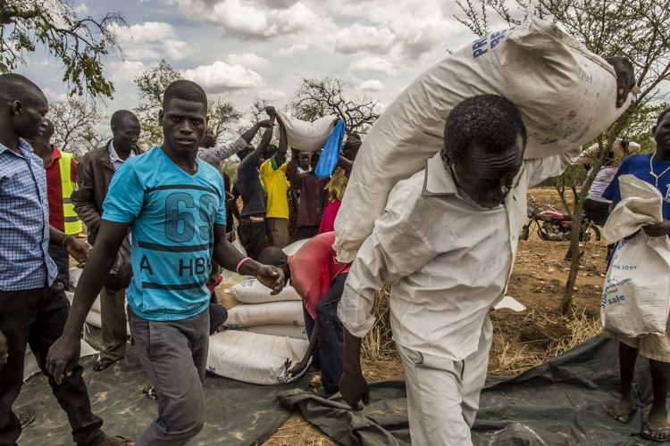 Des réfugiés récupèrent des rations de nourriture attribuées à un groupe de plusieurs familles. Ils prennent les sacs, s'installent dans un coin et se les répartissent © Frederic Noy Des réfugiés récupèrent des rations de nourriture attribuées à un groupe de plusieurs familles. Ils prennent les sacs, s'installent dans un coin et se les répartissent © Frederic Noy