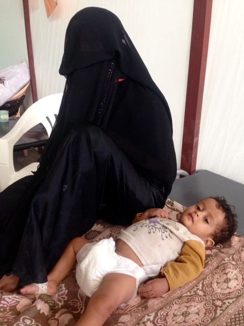 Fatima est assise sur le lit à côté de son fils Ishaq, âgé de 18 mois. Il est soigné dans l'un des centres de traitement du choléra de MSF à Kilo, dans le sud du gouvernorat d'Ibb. Le coût du carburant a considérablement augmenté depuis l'instauration d'un blocus par la coalition dirigée par l'Arabie saoudite en novembre et Fatima ne peut pas payer les frais de transport à destination et en provenance de l'hôpital. 16 novembre 2017 ©MSF