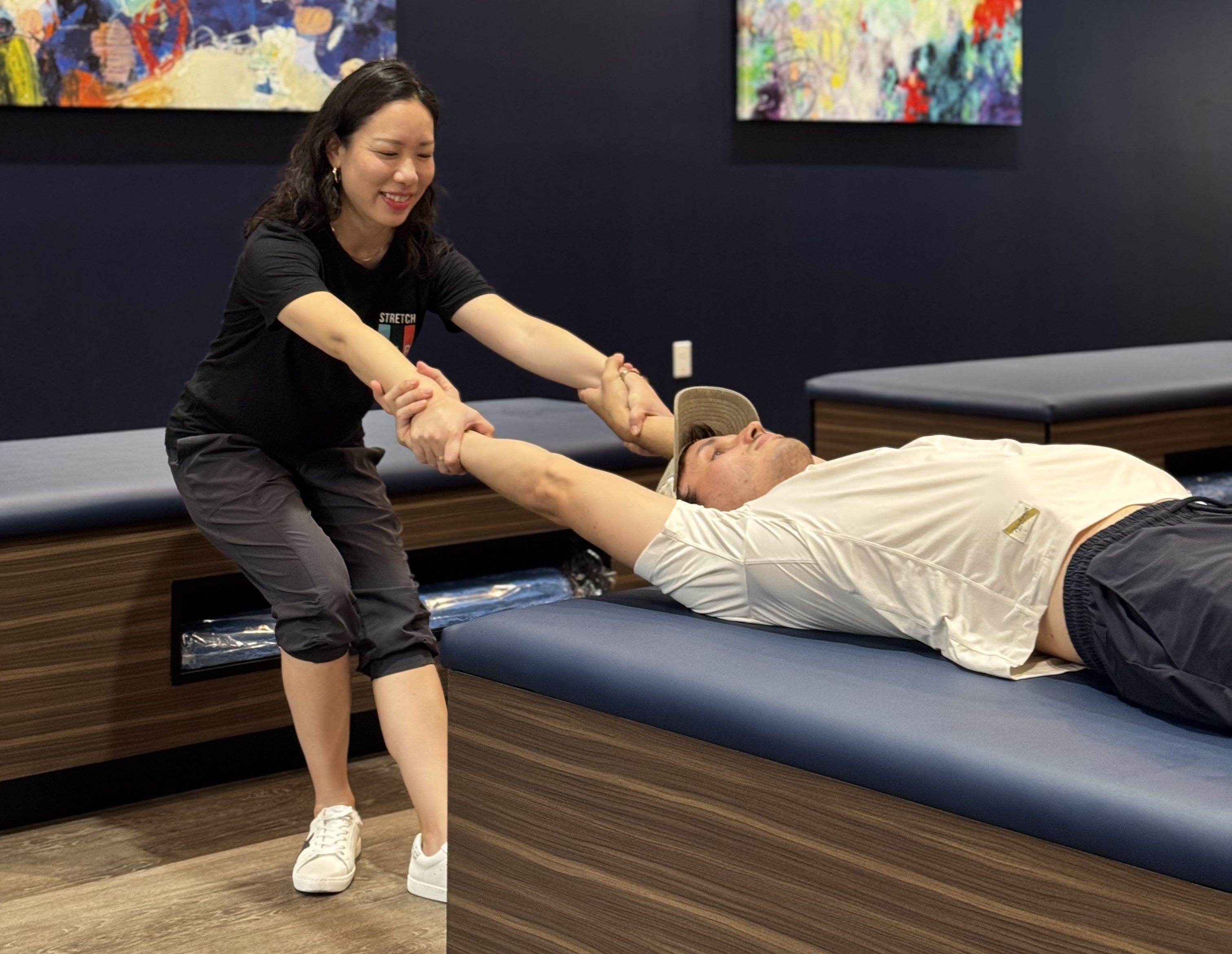 One of StretchLab's certified Flexologists performs assisted stretching on a client, helping to improve flexibility and mobility.