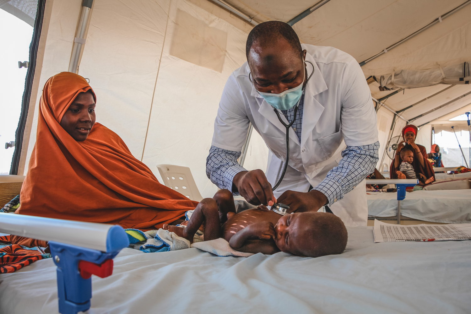 Dr. Bukar M. Galtimar onderzoekt een ernstig ondervoed kind dat is opgenomen in het intramurale therapeutische voedingscentrum (ITFC) in het voedingsziekenhuis Nilefa Kiji, gerund door AZG in Maiduguri, in de staat Borno in Nigeria.