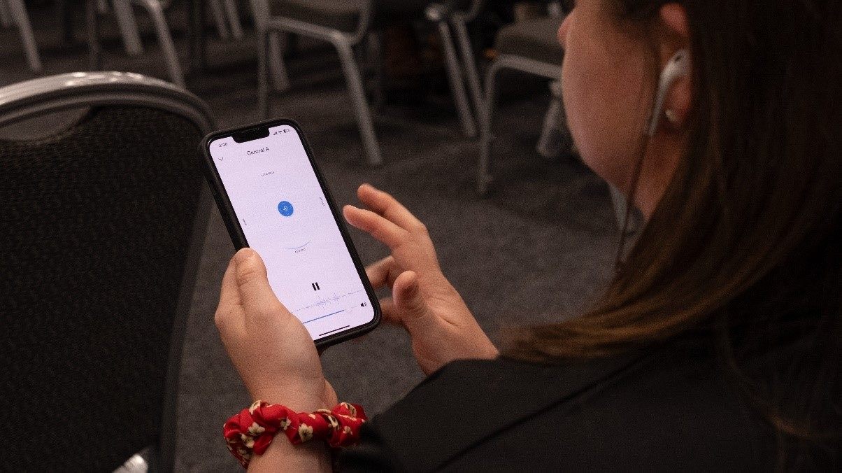 Een aanwezige luistert op haar personal device