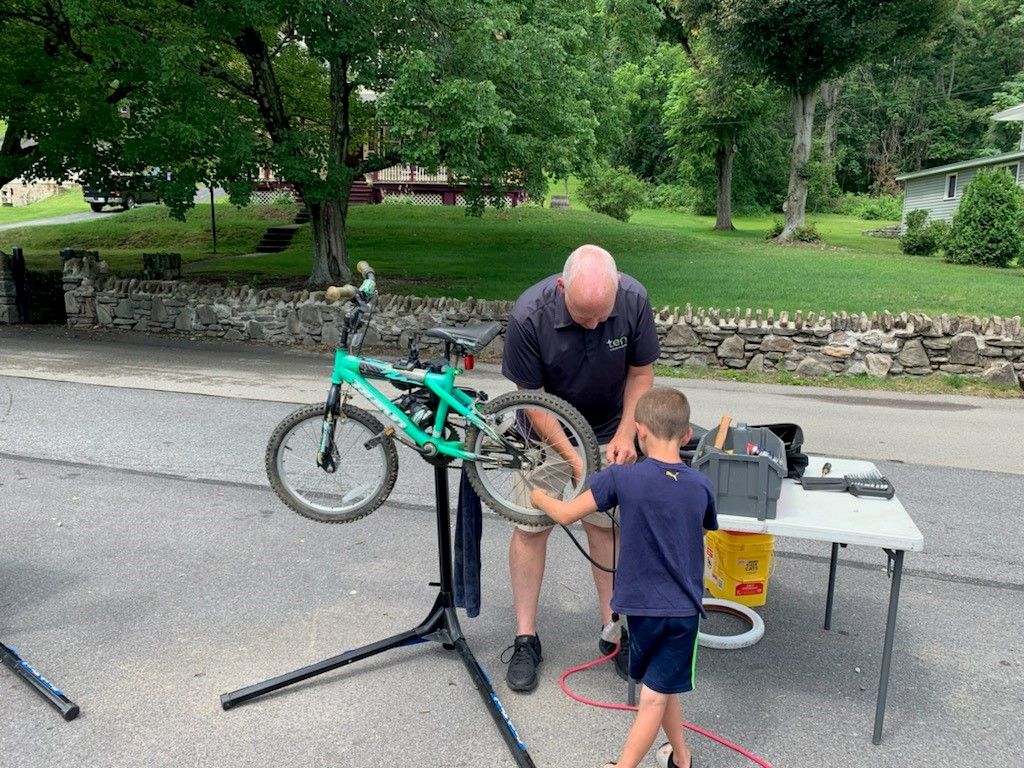 TEN's Rob Campbell completes a tire pressure check before giving the bicycle to a youngster as part of Communicycle's giveaway at Roxbury Park in Johnstown on July 17, 2021.