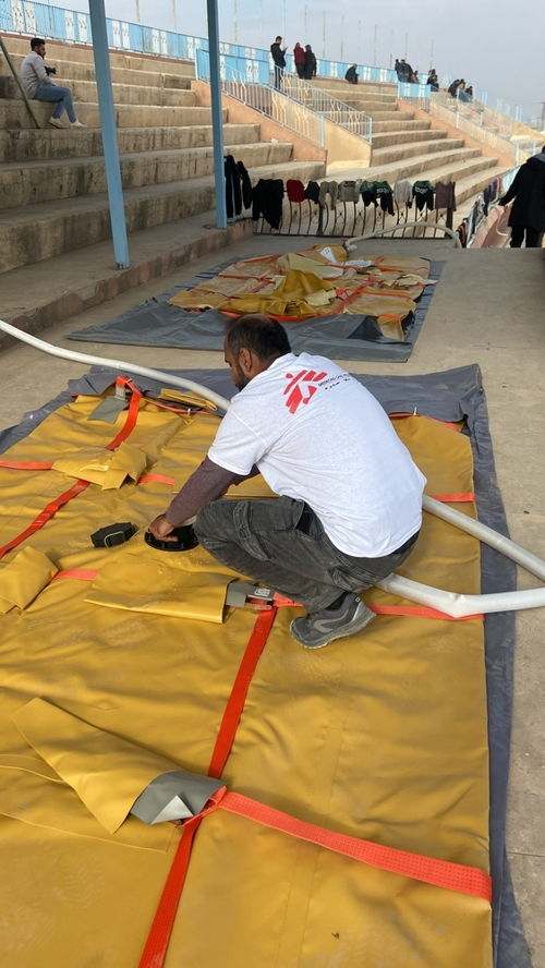 MSF staff checking water installation. Copyright Matthew Cowling/MSF