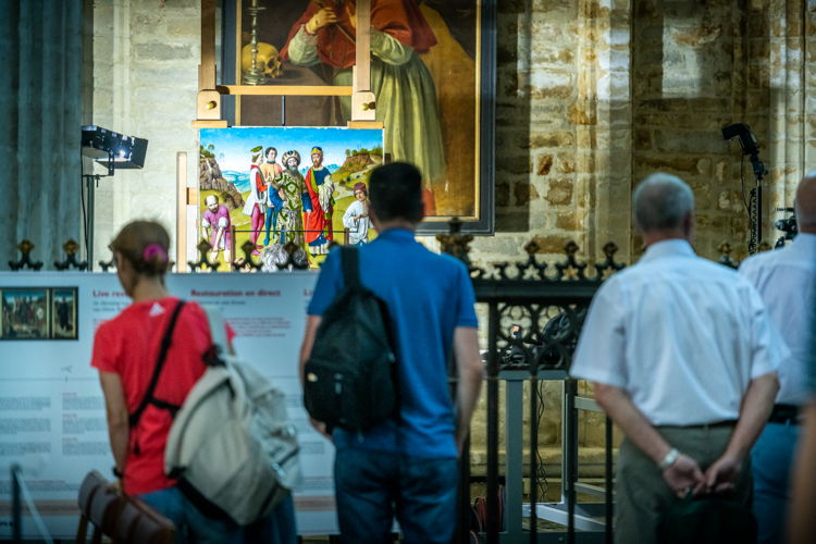 Bezoekers bekijken live de restauratie van De Marteling van de Heilige Erasmus in de Leuvense Sint-Pieterskerk | foto: Rudi Van Beek