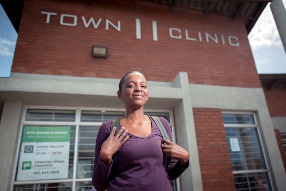 Sibongile leaves the Town 2 Clinic following her consultation. Kuyasa, Khayelitsha, Western Cape, South Africa.  Simbongile’s current DR-TB regimen: bedaquiline, linezolid, clofazimine, terizidone, levofloxacin, pyrazinamide.  Simbongile Xesha  “Last year, end- September, I started coughing and didn’t want to eat. My partner had XDR-TB so I probably caught it from him. He passed away in May this year. I brought myself to the clinic and within a week, in October 2015 I started full treatment for XDR-TB, with monthly supplies of drugs from my local clinic, which included bedaquiline. I live with my mum and two sisters, and our children. I know from Dr Jenny that many patients need bedaquiline. I didn’t have to wait and was taking bedaquiline from the first day of treatment. I think that’s why my sputum started to change so quickly. I stick to my treatment same time every day and I go to a support group. Today I work as a cashier at a frozen yoghurt place in Khayelitsha. I feel great. I’ve been taking bedaquiline for six months now. I take all the tablets at the same time. The medication makes me very nauseous and knocks me out for one or two hours. But it makes me strong too.” Photographer: Sydelle WIllow Smith 