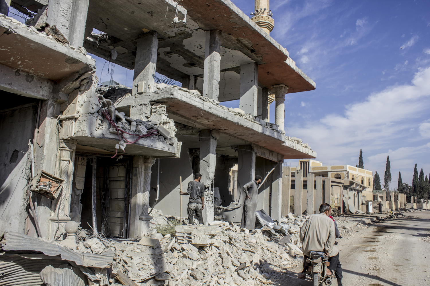 A family cleaning their house from the rubble after being destroyed by the war. Al Mishlab, east of Raqqa city. Credit: Diala Ghassan/MSF
