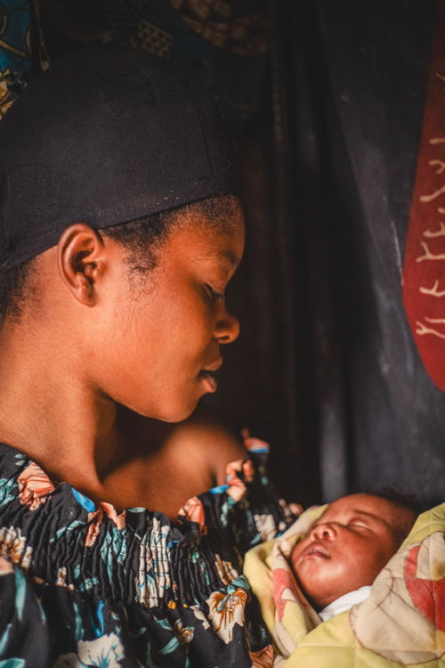 Copyright: Philémon Barbier Countries: Democratic Republic of Congo Date taken / Date Recorded: 04 January, 2024 Caption / Description: Alice Feza, 19, looks at her child Rehema Alliance, born on 22 December 2023, in the displaced persons site of Kanyaruchinya, north of Goma, North Kivu, in the Democratic Republic of Congo, on 4 January 2024.