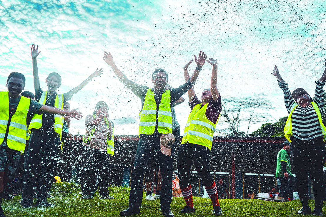 Volunteers rejoice as water finally flows through the pipes.