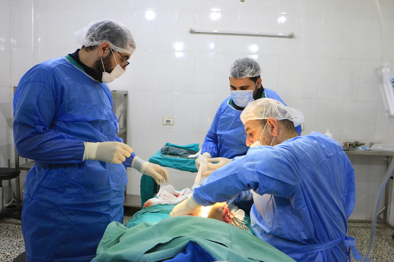 Title: MSF response to the earthquakes through Atmeh Hospital Copyright: Abdul Majeed Al Qareh Countries: Syria Date taken / Date Recorded: 11 February, 2023 Caption / Description: Syrian doctors operate on a patient in a hospital in Atmeh. The equipment for the operating room of this hospital comes from a donation from the MSF team in Atmeh. February 11, 2023.