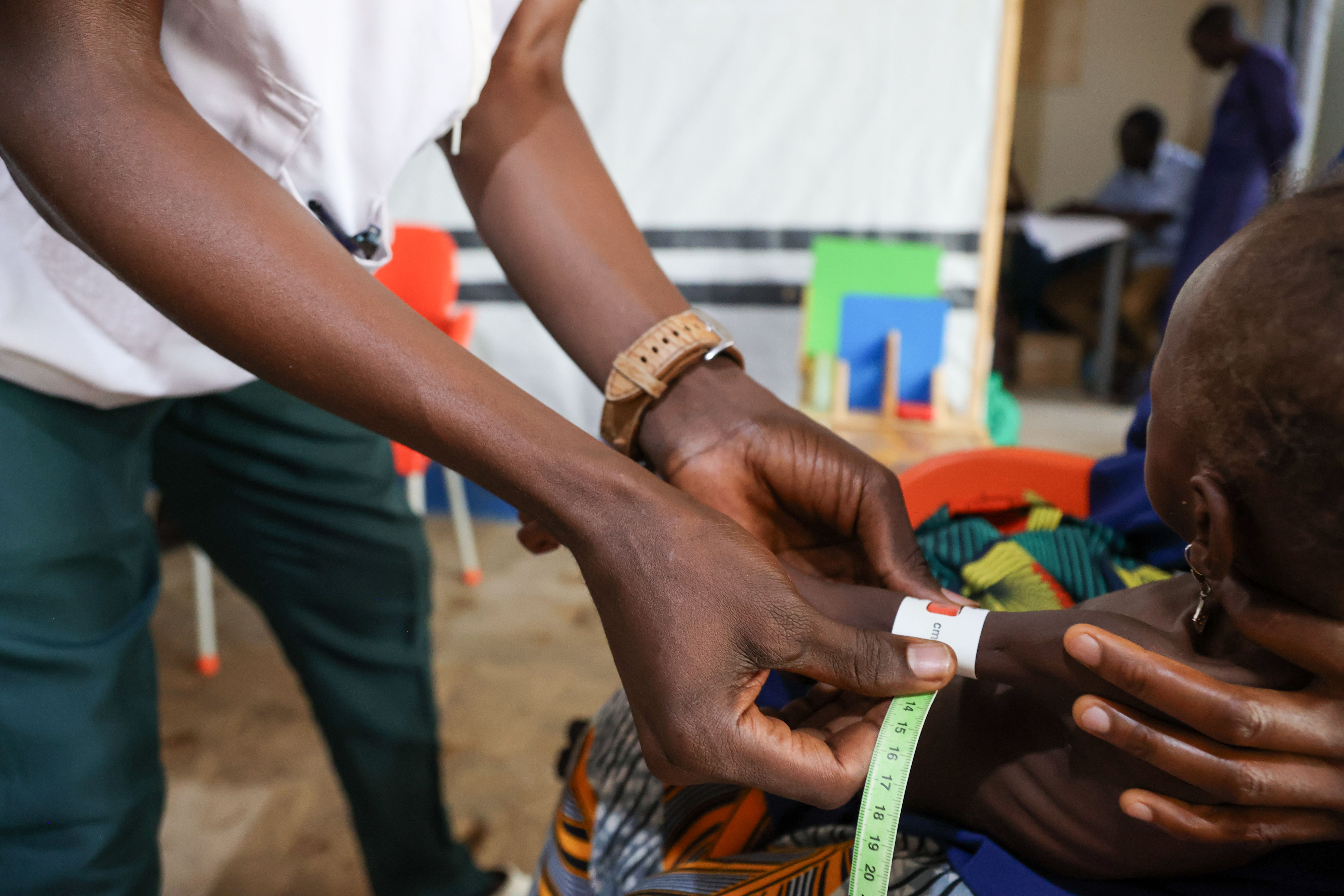 Verpleegkundige met MUAC-bandje waarmee de omtrek in het midden van de bovenarm gemeten wordt - (c) Miguel Godonou/MSF - 15 July, 2024 Verpleegkundige met MUAC-bandje waarmee de omtrek in het midden van de bovenarm gemeten wordt - (c) Miguel Godonou/MSF - 15 July, 2024