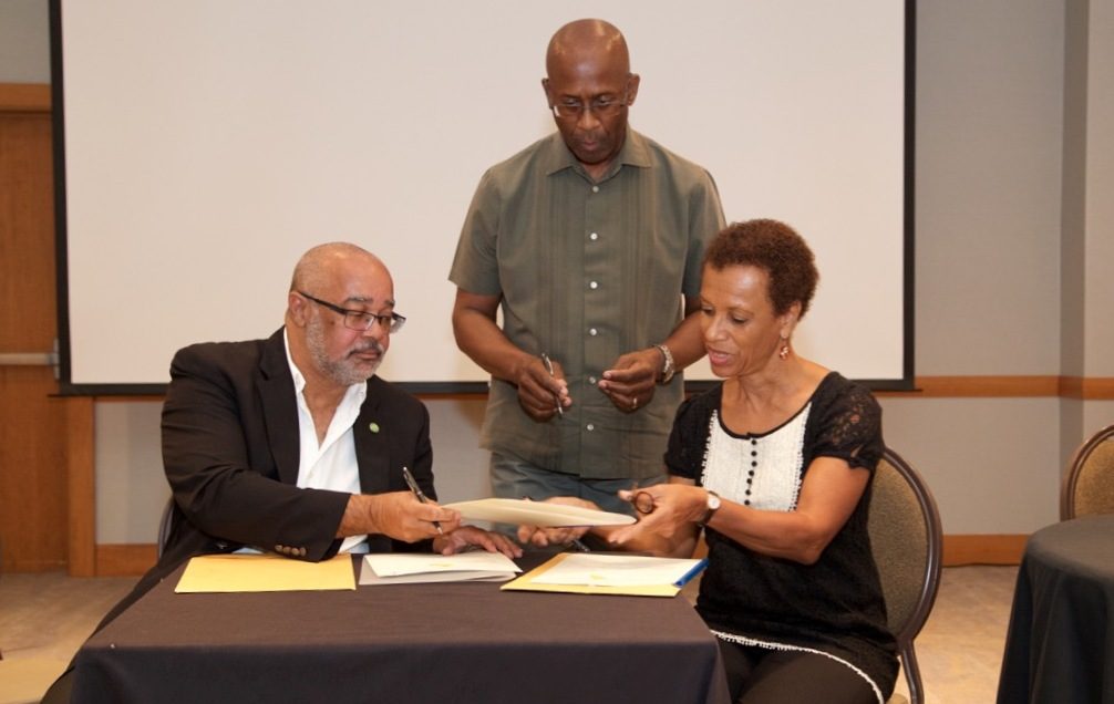 OECS Director General, Dr. Didacus Jules, and Professor Jessica Byron, Director of the UWI Institute of International Relations, complete MOU signing.