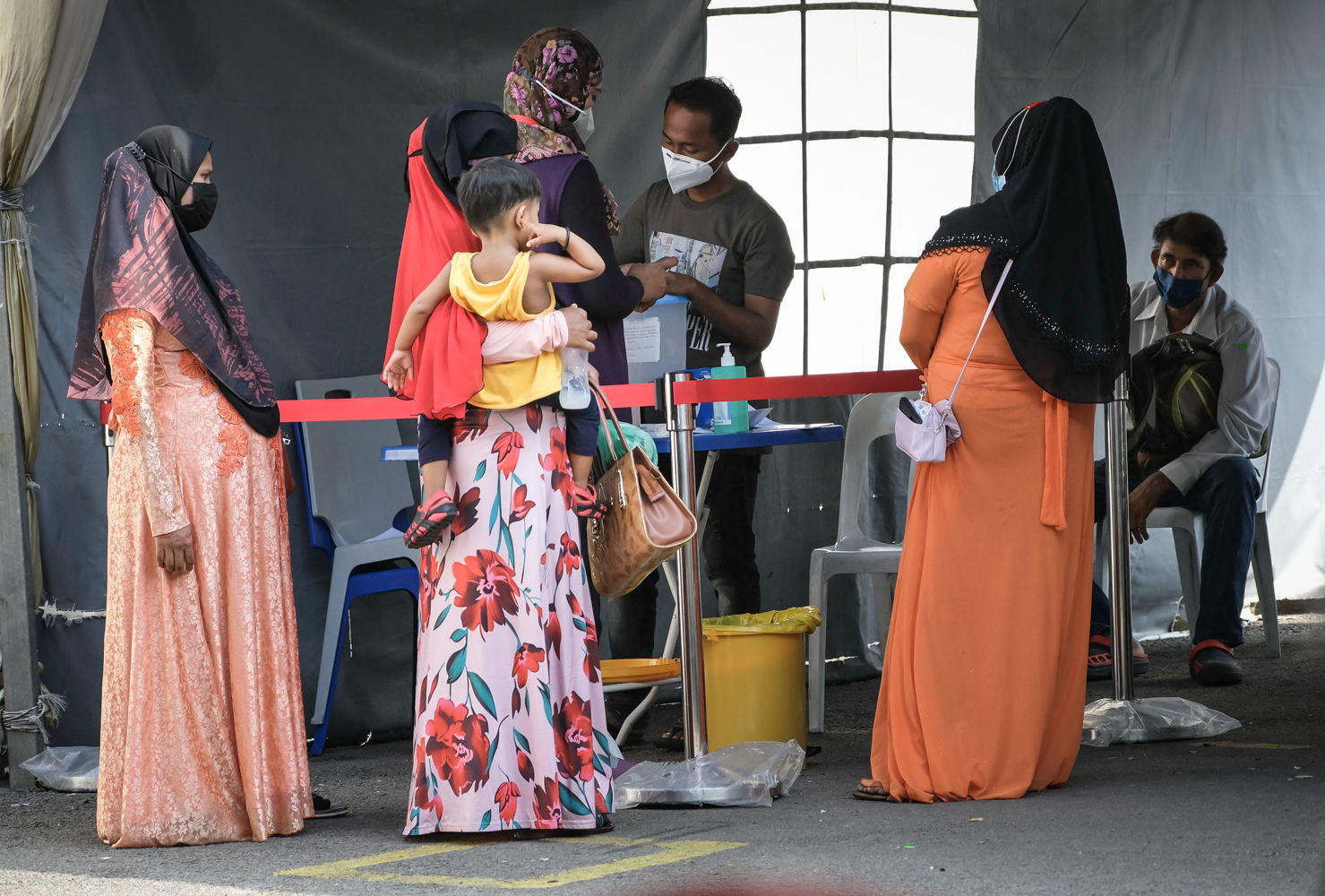 Women from the Rohingya community in Malasysia, one of whom is pregnant, registering at the triage area of MSF clinic in Butterworth, Penang. The MSF clinic in Butterworth receives many antenatal patients. Antenatal care in the MSF clinic includes ultrasound scans, blood tests and regular follow up appointments. MSF also collaborates with Penang Birth, a grassroots volunteer-based organisation, to provide antenatal classes to prepare mothers-to-be throughout their pregnancies and births. Photographer: Kit Chan. Date: 10/05/2022. Location: Malaysia 