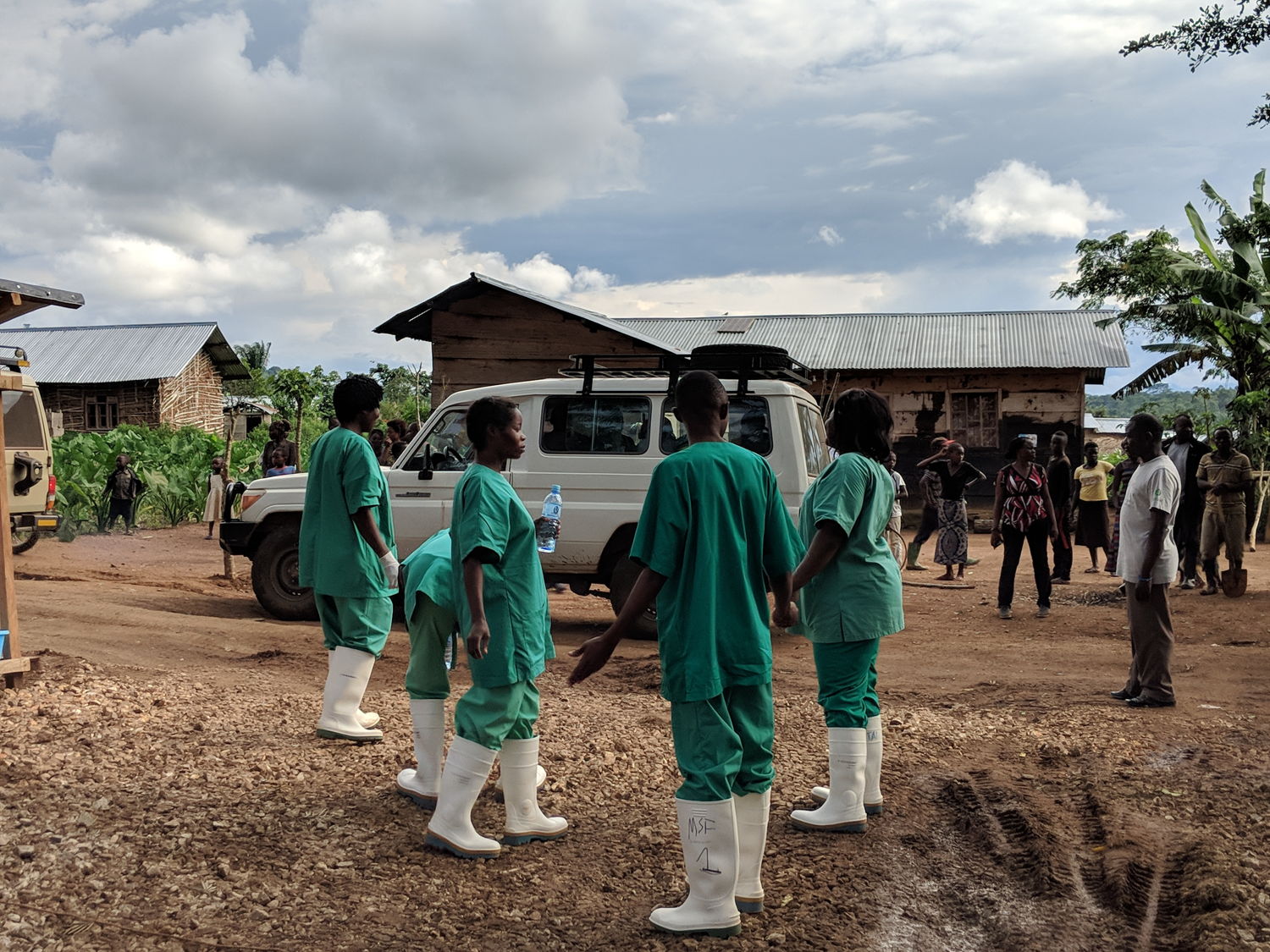 One of the first cured patients coming out of the treatment center (CTE.) Cheered by the health staff. Photographer: Karin Huster/MSF