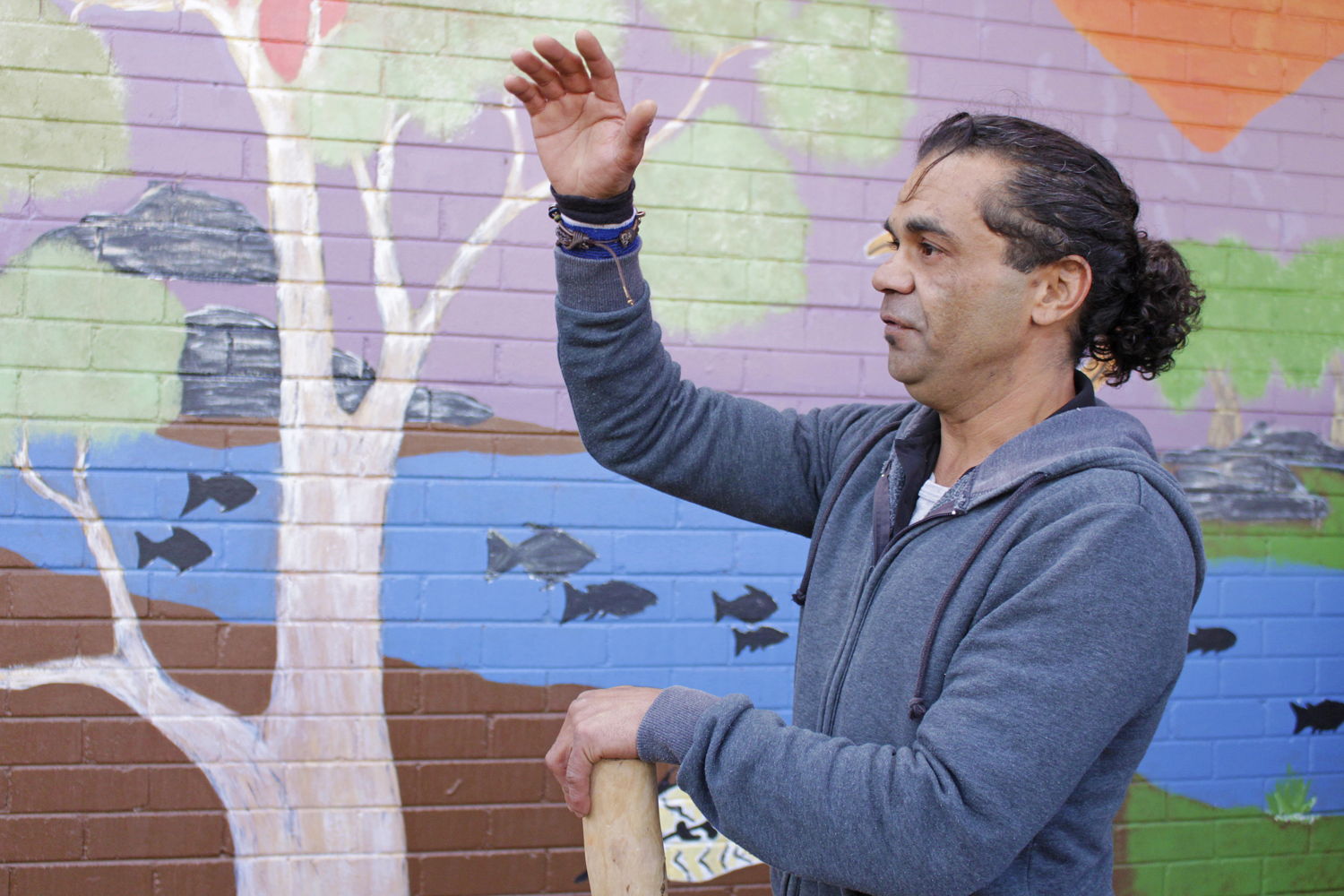 Artist Daniel Williams in front of one of the murals in Canberra. Image: Adam Spence, ANU.