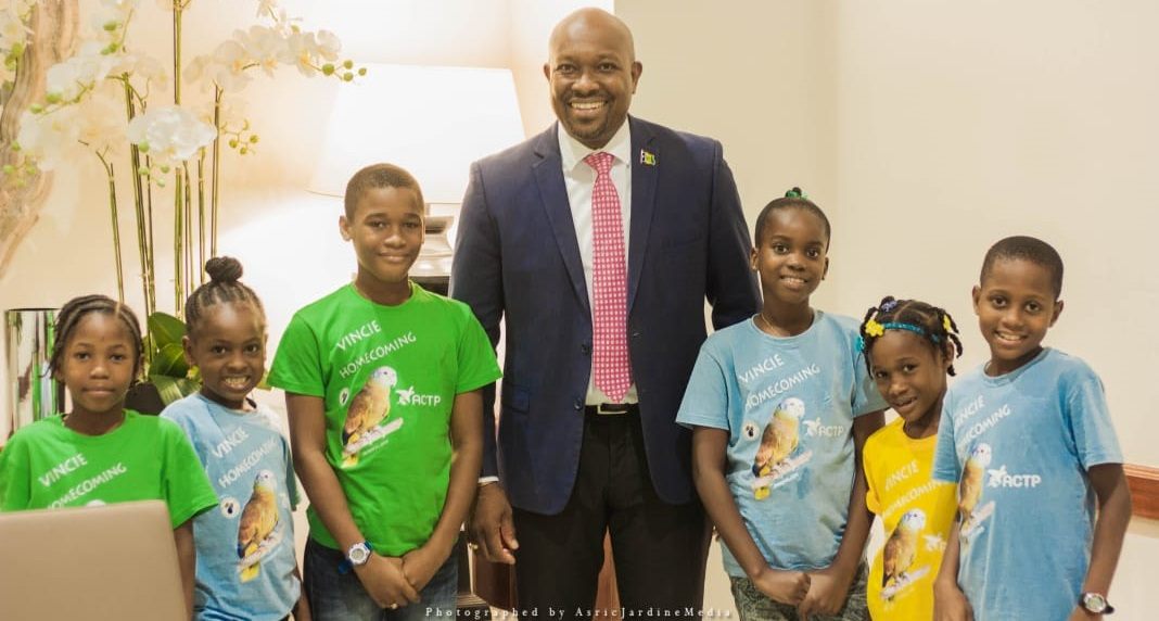 Hon. Saboto Caesar, Minister of Agriculture, Forestry, Fisheries, Rural Transformation, Industry and Labour, photographed with students in anticipation of the homecoming ceremony for the Amazona Guildingii parrots on November 4, 2019.