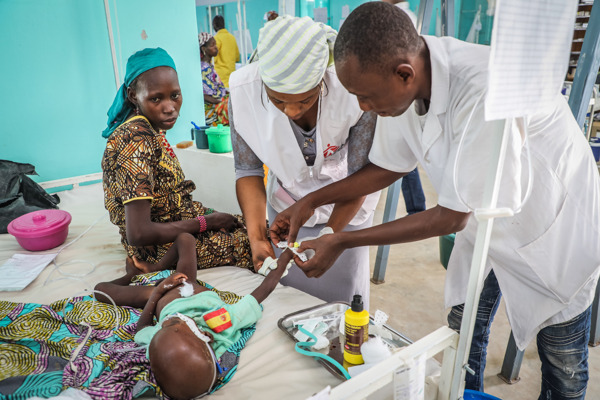 Credit: MSF/Laurence Hoenig. Taken 6 September 2018 in Magaria, Niger. Staff insert an intravenous catheter for a patient in the intensive care unit.