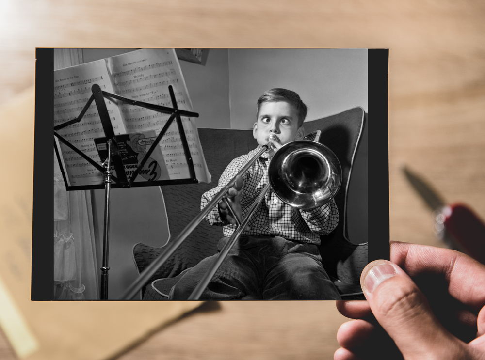 Cross-eyed boy playing slide trombone / AKG4810613