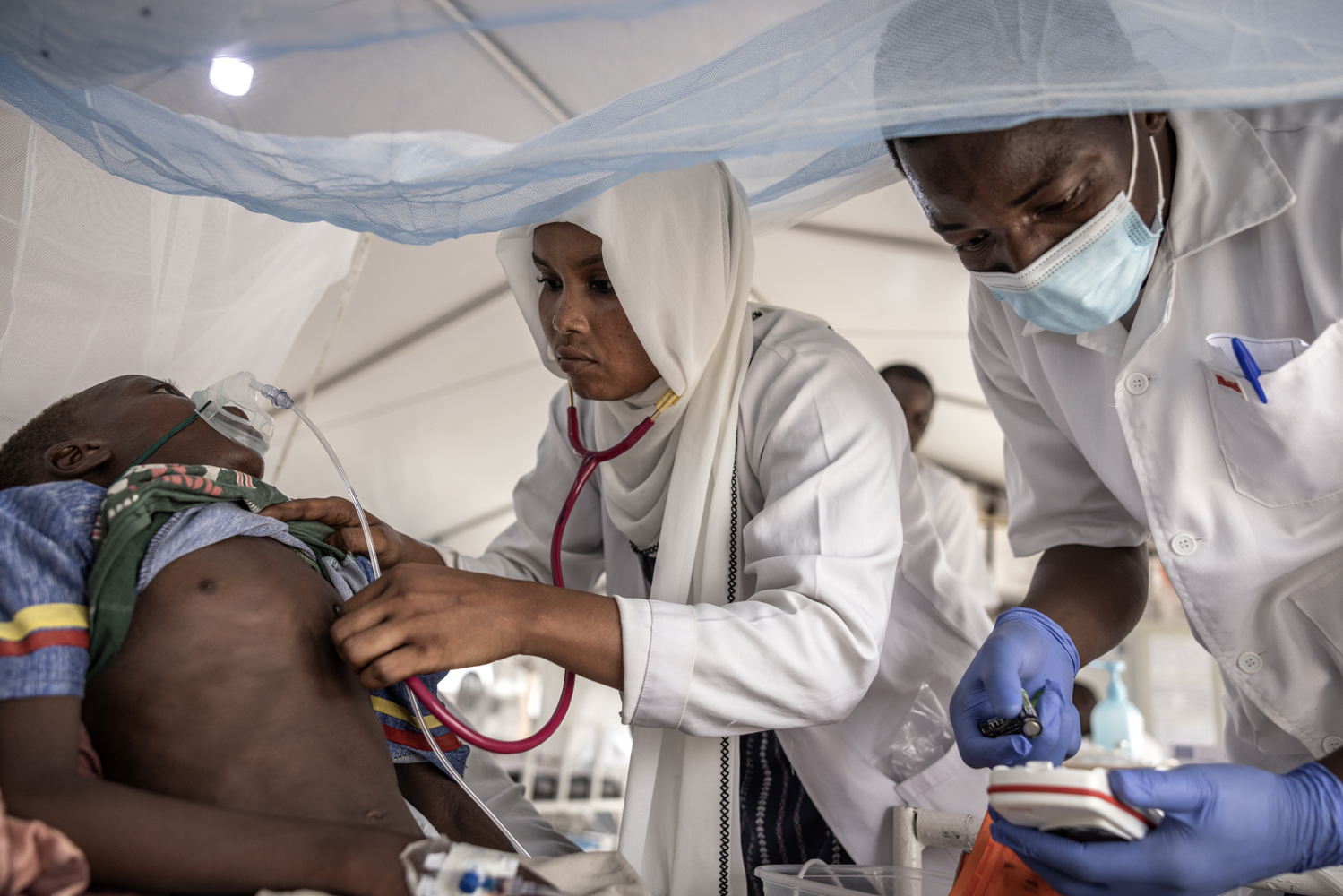 Date taken / Date Recorded: 07 August, 2024 Caption / Description: Sudanese doctor Faiza Hamed Hangata, 24, who is from El Geneina in Darfur, examines 10-year-old Haidara Atim, who was suffering from tracheal bronchitis, in the intensive care unit at the MSF Hospital in Metche, in eastern Chad, August 7, 2024. Metche camp hosts about 40,000 Sudanese refugees who have fled violence in Darfur. Finbarr O’Reilly/VII Photo.