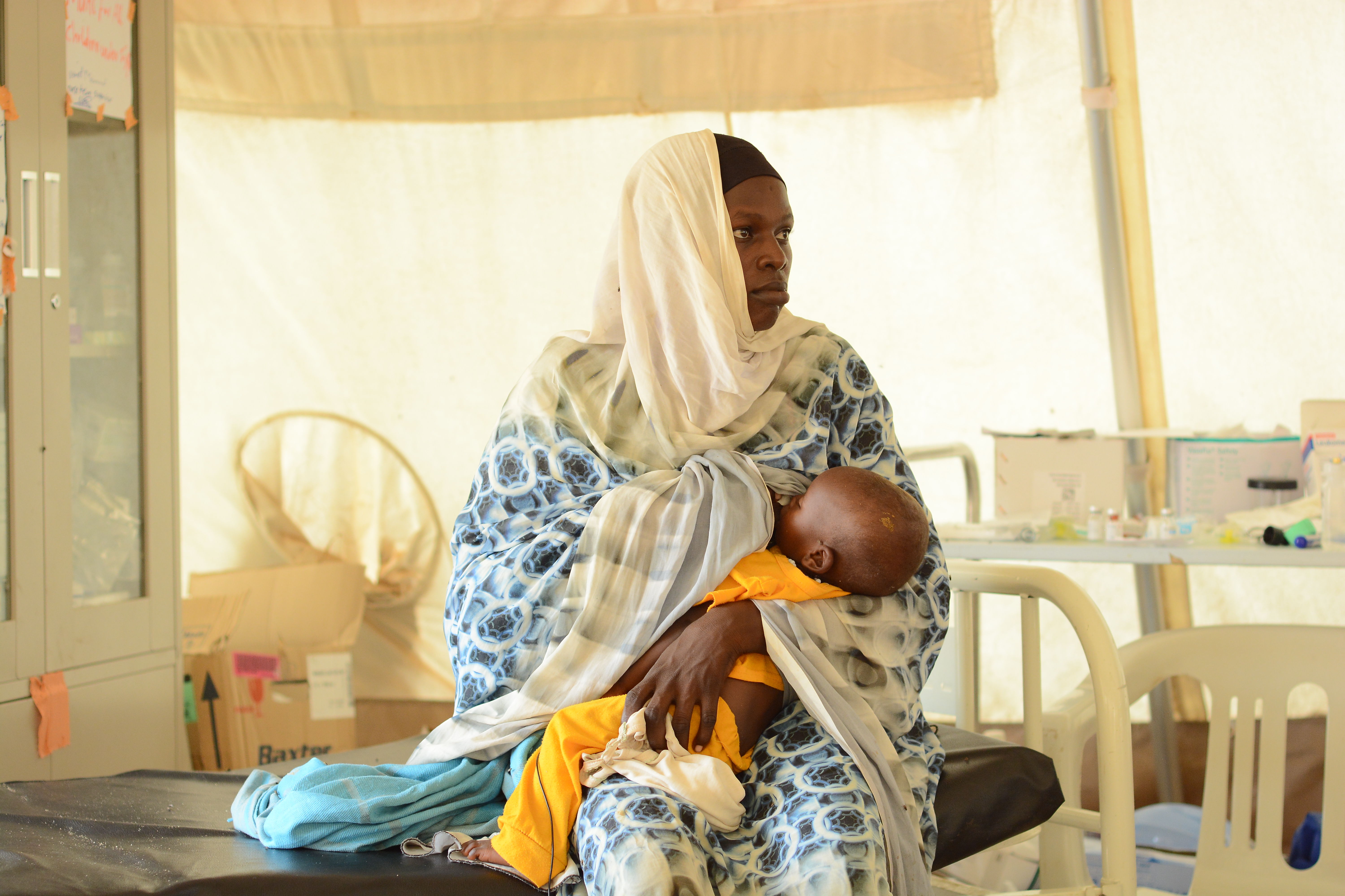 Saadiah, with her daughter at the MSF clinic in Zamzam Camp, North Darfur, watches as a nurse conducts a MUAC screening to assess her child’s health. Zamzam camp near El-Fasher | 30/08/2024 | Photographer: Mohammed Jamal.