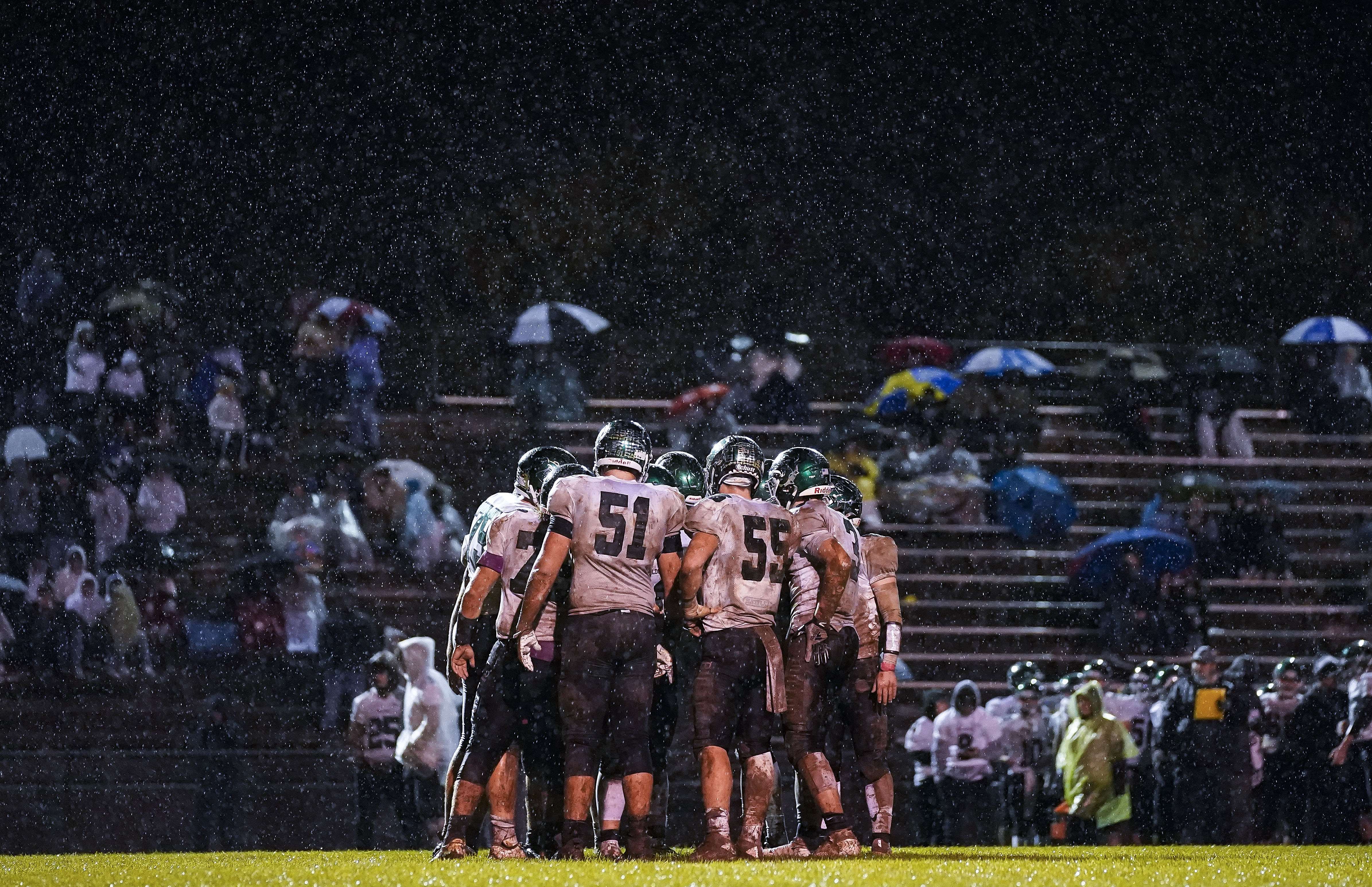 Grace Hollars / Indy Star; Alpha 9 II, FE 70-200mm F2.8 GM OSS, f2.8, 151mm, 1/800, f/2.8, ISO 8000; Monrovia Bulldogs huddle on the field as the rain falls Friday, Oct. 29, 2021 at Speedway High School, in Indianapolis. The Speedway Sparkplugs defeated the Monrovia Bulldogs, 12-6 advancing to the Sectional Class 2A Finals.