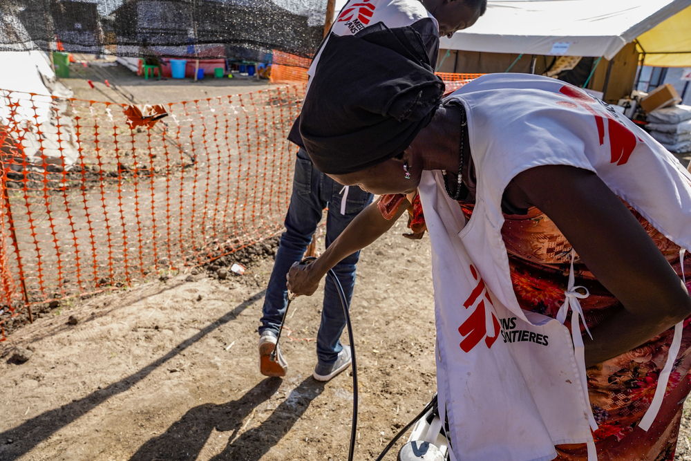 MSF staff disinfects people entering and exiting the Cholera Treatment Center with chlorinated water, reducing the risk of spreading cholera through contaminated soil. Location: Malakal / Date: 26/11/2024 / Photographer: Paula Casado Aguirregabiria.