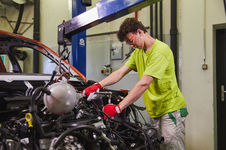 A male trainee is working on the engine compartment of the
ŠKODA MOUNTIAQ. A total of 2,000 working hours went into
the production of this vehicle.