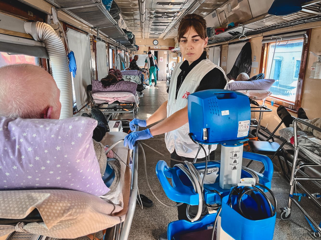 Title: Medical evacuation from Kherson Copyright: Verity Kowal/MSF Countries: Ukraine Date taken / Date Recorded: 22 October, 2023 Caption / Description: MSF nurse, Halyna Milovus, checks the blood pressure of a patient on the MSF medical evacuation train. This is one of 150 patients evacuated from Kherson after the hospital they were at was shelled. Patients were transferred to other health facilities around Ukraine. Title: Medical evacuation from Kherson Copyright: Verity Kowal/MSF Countries: Ukraine Date taken / Date Recorded: 22 October, 2023 Caption / Description: MSF nurse, Halyna Milovus, checks the blood pressure of a patient on the MSF medical evacuation train. This is one of 150 patients evacuated from Kherson after the hospital they were at was shelled. Patients were transferred to other health facilities around Ukraine.