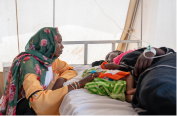 Our clinic in Adré transit camp: Here I am sitting at the bedside of Manahil M. – a young mother who became so seriously ill with malaria that she lost consciousness. Her baby is lying next to her, whom a colleague and I took care of until the father arrived. Fortunately, Manahil was soon doing well again thanks to the treatment.