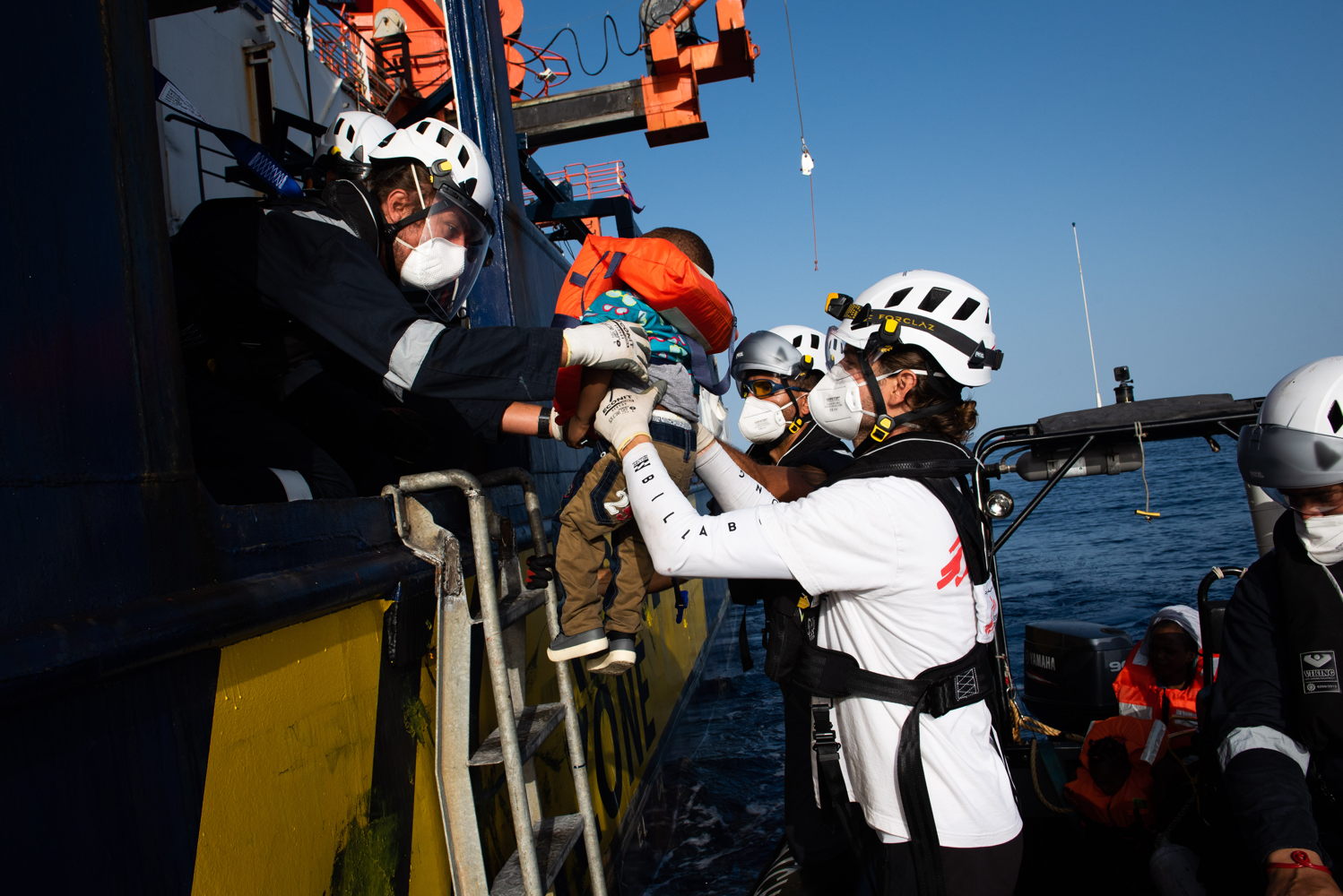 At the first light on August 23, the Sea-Watch 4 morning look out spotted a small black vessel in international waters, some 31 nautical miles from the coast of Libya. The overcrowded and unseaworthy rubber boat carried 60 men and women, as well as 9 children and 28 unaccompanied minors. Securing these lives at risk at sea, rescue crew distributed life vests, before bringing everyone safely on board. All survivors were triaged by MSF medics and assisted by the Sea-Watch protection team upon embarkation. The operation was complete at 09:30am ship time and the Sea-Watch 4 resumed patrolling at the deadliest border in the world.
Copyright: Chris Grodotzki/Sea-Watch.org