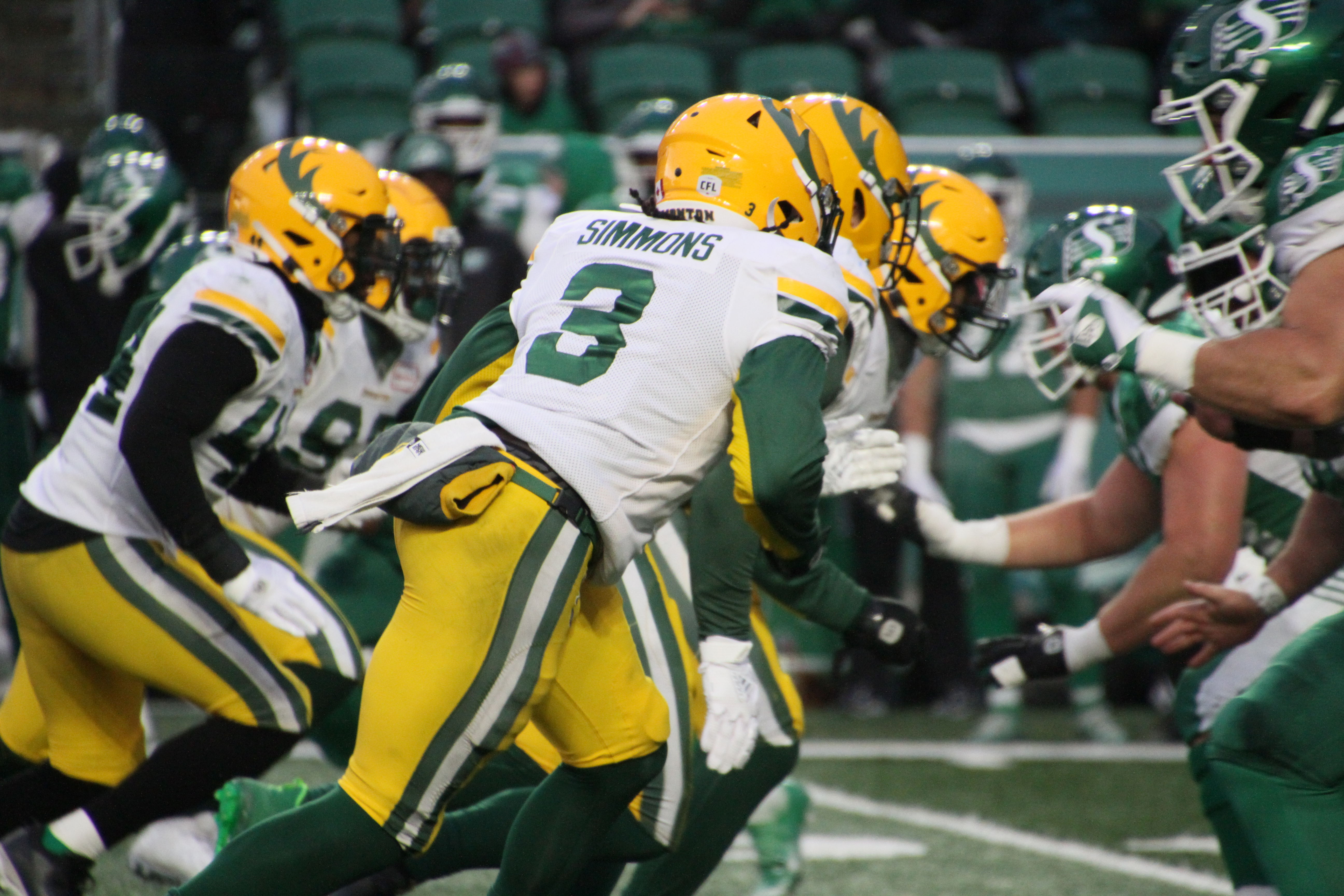 Antonio Simmons rushes Saskatchewan Roughrider quarterback Cody Fajardo