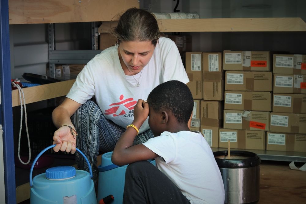 Stefanie, responsable del equipo médico de MSF con uno de los niños por el Ocean Viking. ​ Hannah Wallace Bowman/ MSF