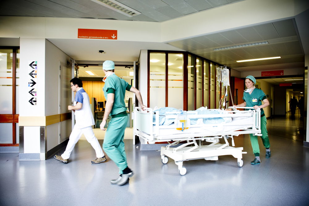 Medewerkers brengen een patiënt van de operatiezaal terug naar de kamer