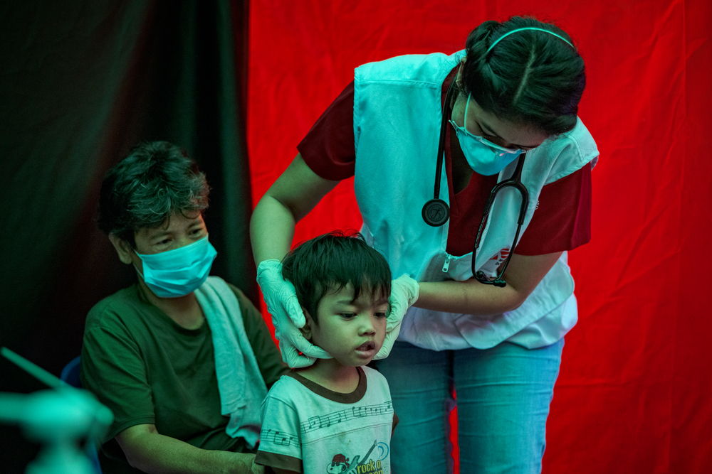 Agustina watches as Trisha Thadhani, MSF TB doctor, conducts a medical evaluation of her grandson Ion, at one of MSF's active case-finding sites for tuberculosis on March 13, 2023 in Tondo, Manila, Philippines | Date taken: 13/03/2023 | Photographer: Ezra Acayan | Location: Philippines