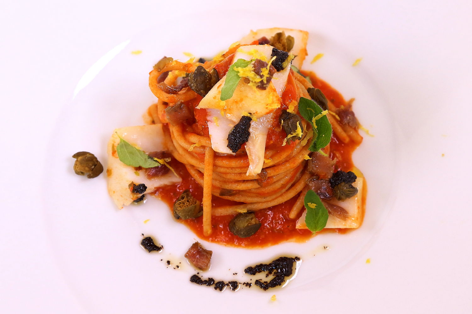 Spaghetti integrali Damigella con pomodorini del Piennolo, baccalà origanato, capperi, acciughe del Cantabrico e aglio fermentato