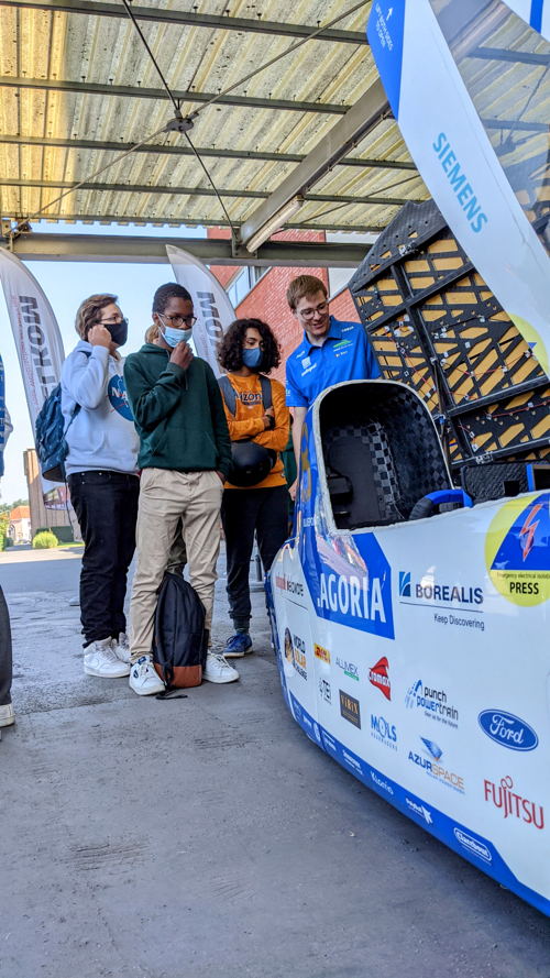 Scholieren verzamelen zich rond de zonnewagen van het Agoria Solar Team