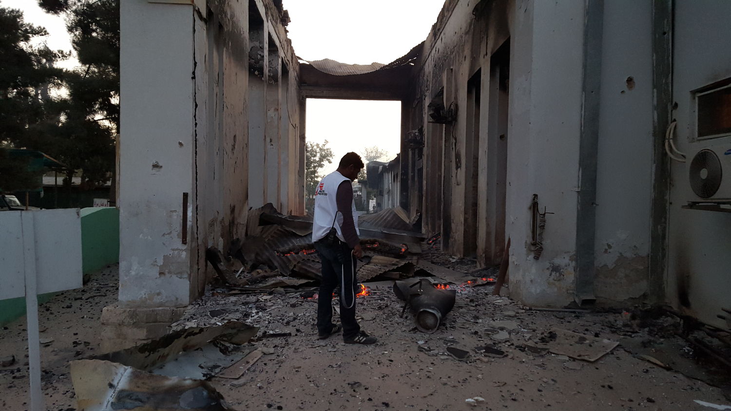 Een medewerker overschouwt de schade na de aanval op het traumacentrum in Kunduz